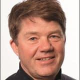 Portrætfoto af John Sloth med neutral baggrund.